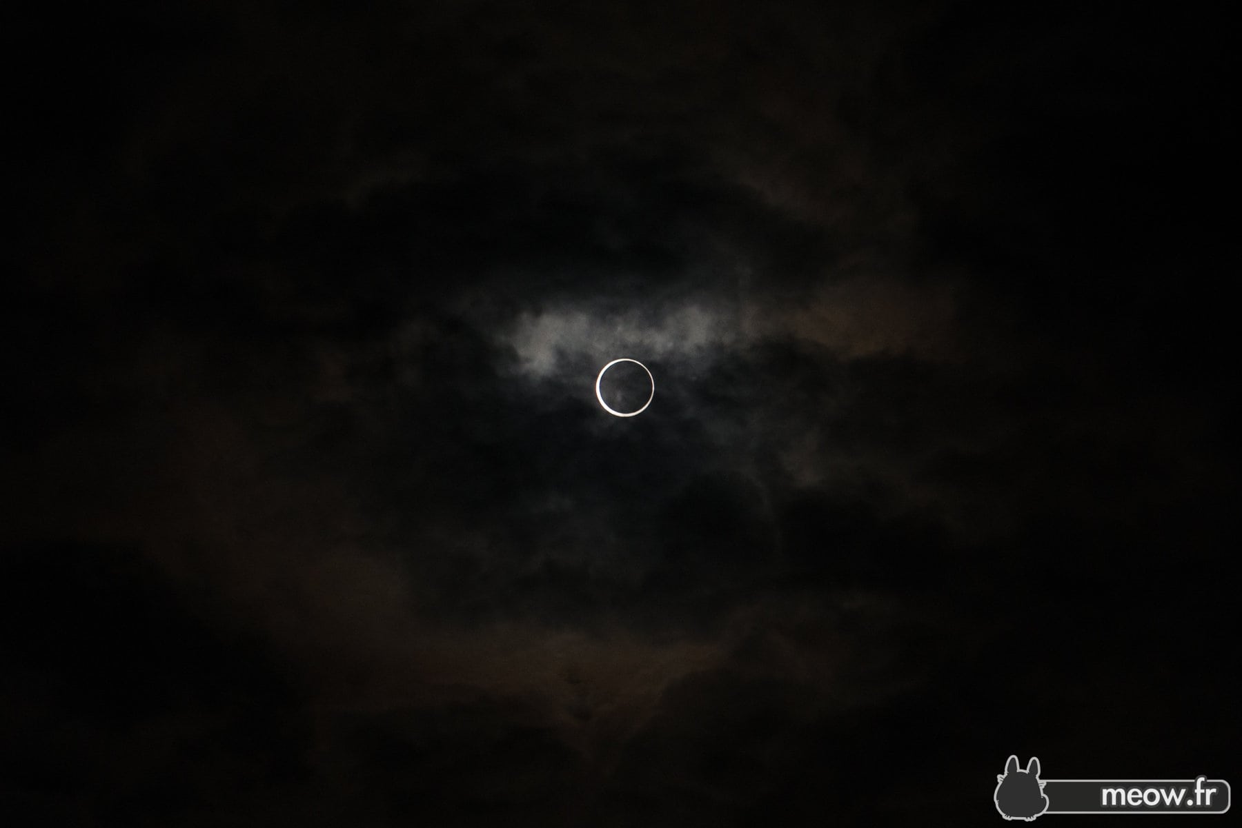 Solar eclipse with suns corona against dark, cloudy sky in Japan 2012.