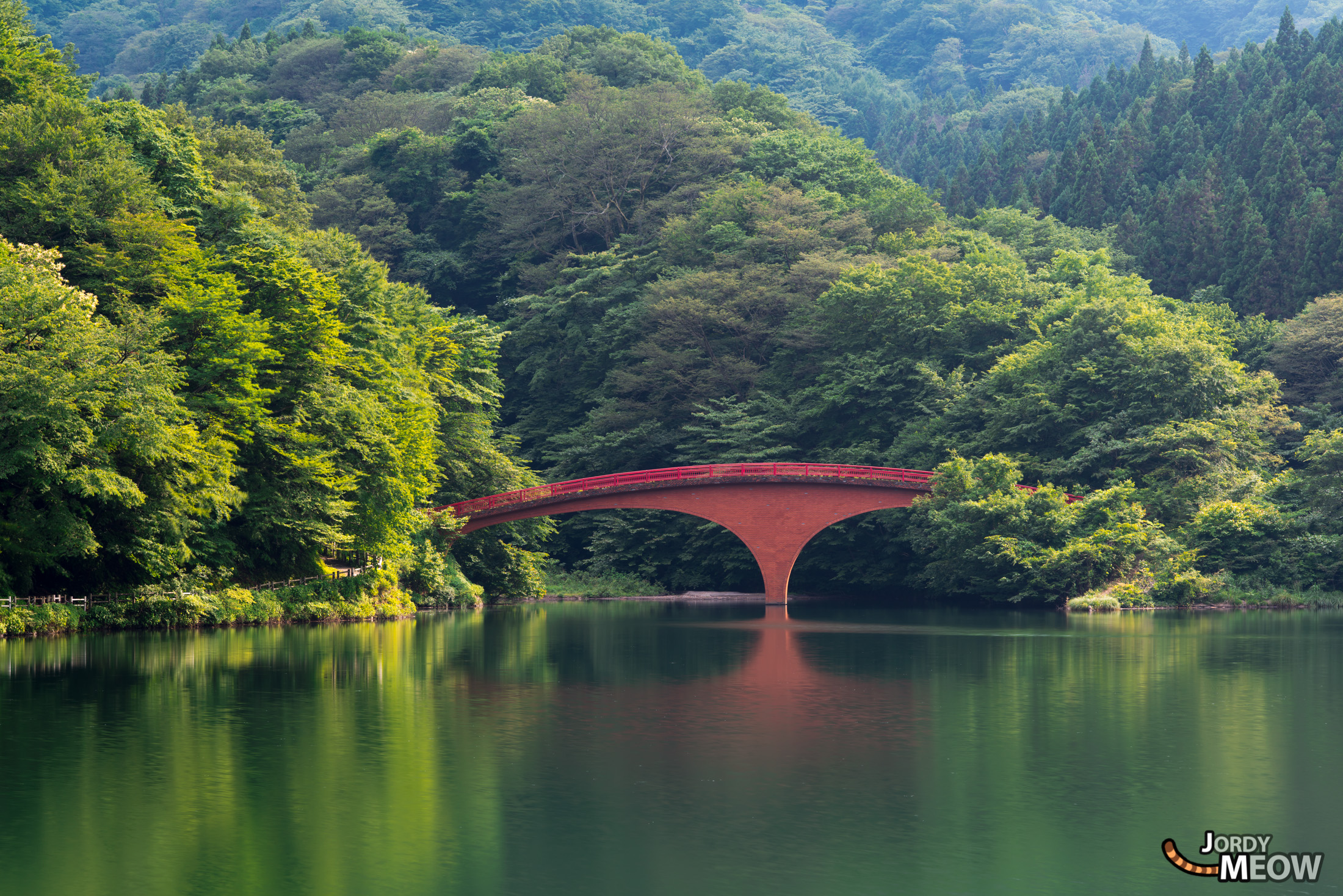 Enigmatic Red Bridge in Gunma, Japan - Tranquil, captivating, mysterious scene in lush nature.