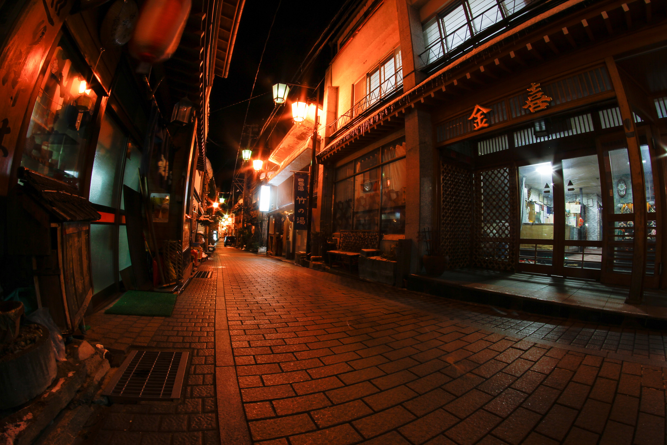 Discover the enchanting alleyways of historic Shibu Onsen, Japan, filled with lantern-lit wooden buildings.