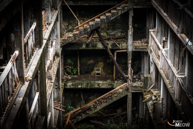 Exploring the eerie ruins of Gunkanjima, Japan, with shadows and decay.