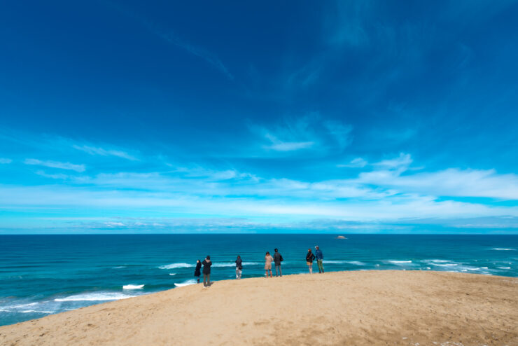 Sands of Serenity: Golden dunes against blue skies and turquoise waters in Tottori, Japan.