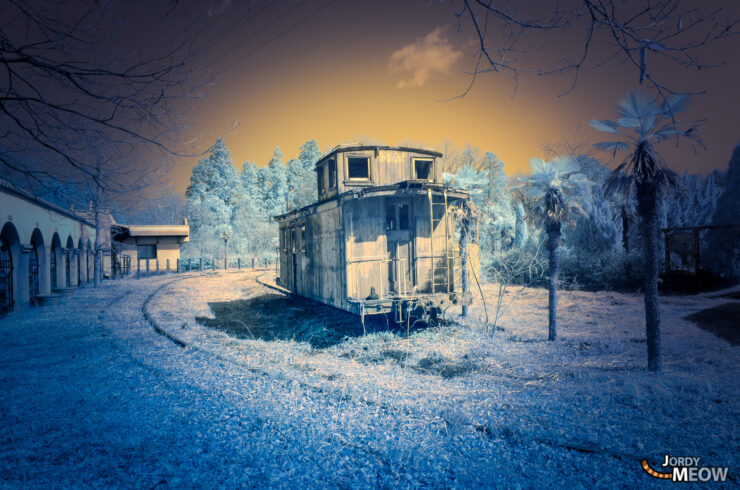 Eerie infrared photo of abandoned cowboy town in Japan, showcasing isolation and mystery.