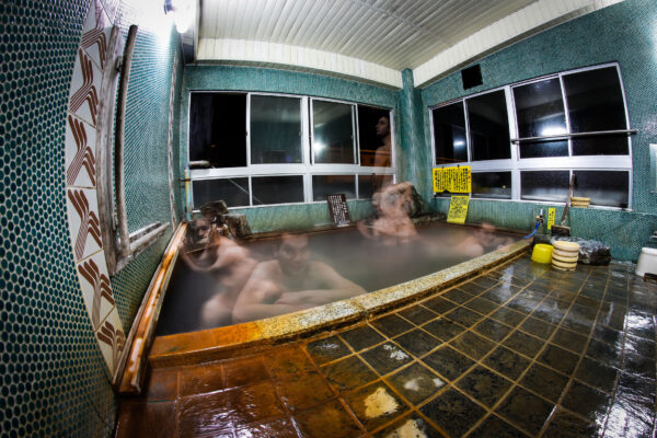 Tranquil Japanese hot spring retreat with steaming mineral-rich water and relaxing atmosphere.