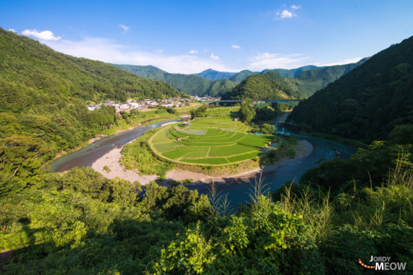 Tranquil terraced rice fields in Shimizu Town, Japan, nestled amidst lush mountains and valleys.