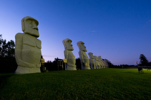 Enigmatic Moai statues in Hokkaido grassy field, inviting contemplation on cultural heritage.