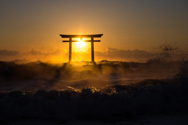 Sunset silhouette of iconic torii gate at serene Oarai Isosaki Shrine in Japan.