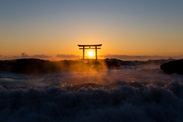 Sunset view of Oarai Isosaki Shrine in Japan, with iconic torii gate silhouette.