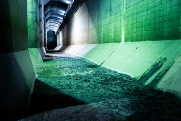 Exploring the Green Underground Passage - Industrial design with vibrant green walls and debris-covered floor.