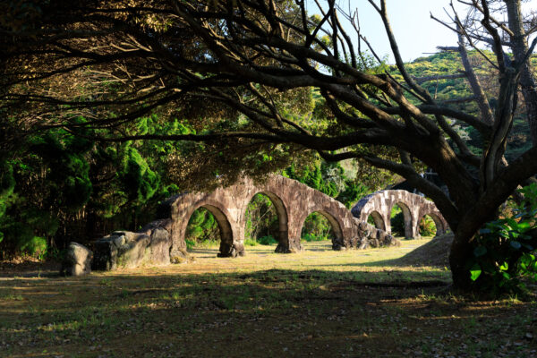 Enchanting stone archways in lush greenery at Niijima Water Park.