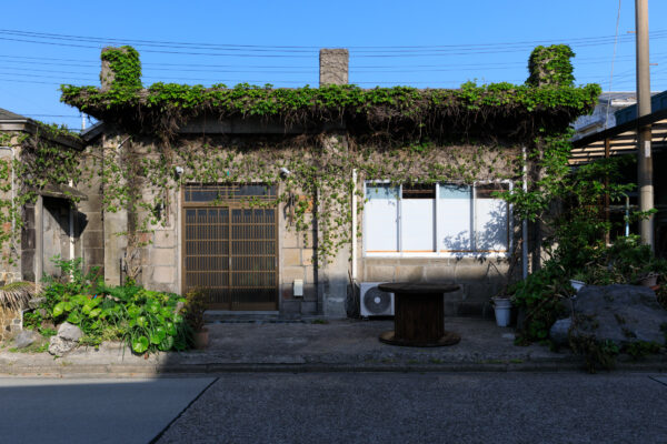 Quaint Japanese village with green roof, surrounded by lush vegetation in Niijima.