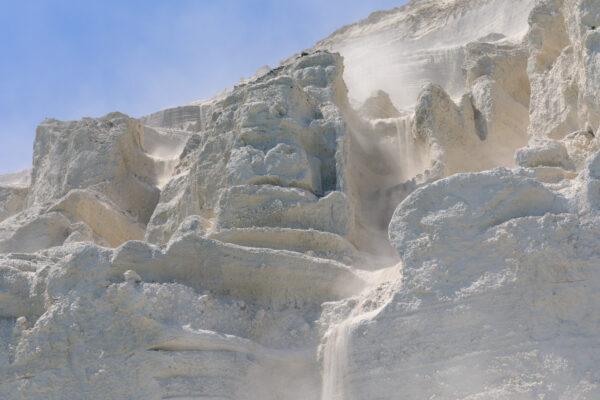 Majestic White Cliffs of Niijima in Japan, showcasing snow-white mineral coating and waterfall.