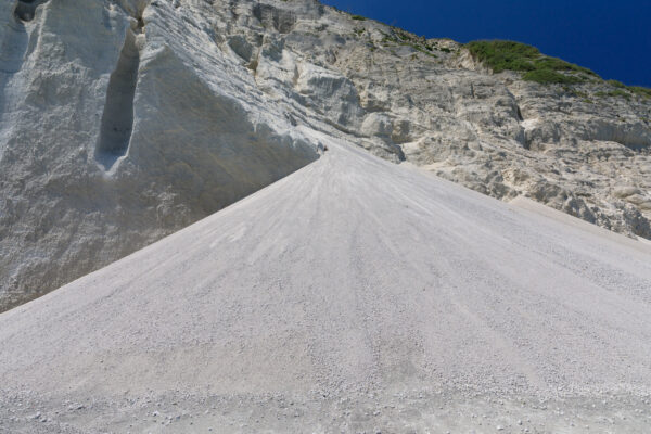 Niijimas Unique White Cliffs: Towering rhyolite cliffs against vivid blue sky, with lush greenery.