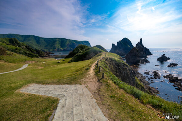 Explore stunning Kuniga Coastline in Nishinoshima, Japan with sea-eroded cliffs and pastoral scenes.