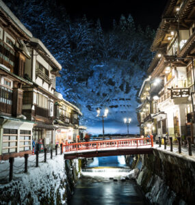 Enchanting winter scene of Ginzan Onsen in Japanese Alps - serene and magical ambiance.