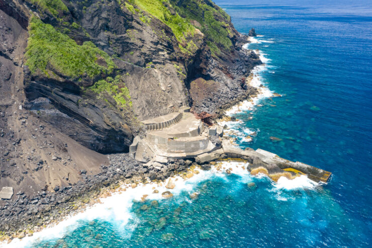 Remote volcanic island Aogashimas cliffs, coves, azure sea