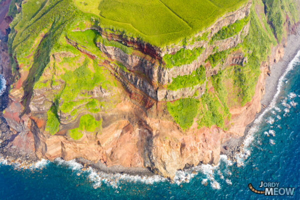 Awe-inspiring Aogashima volcanic island landscape with lush greenery, striking crater, and azure waters.