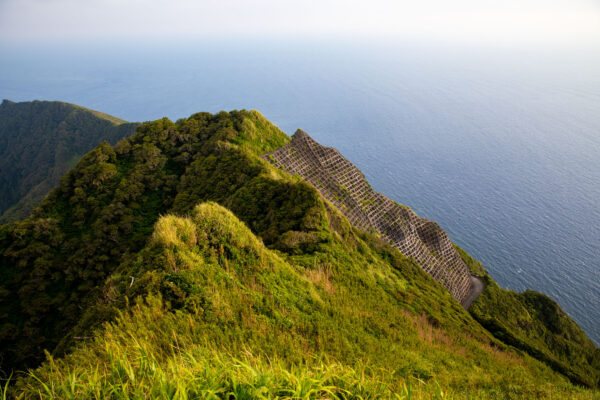 Remote volcanic island in the Philippine Sea, showcasing lush green hills and volcanic slopes.