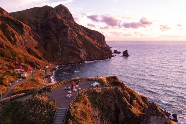 Tranquil sunset views on remote Rebun Island, Japan, showcasing majestic cliffs and serene harbor.