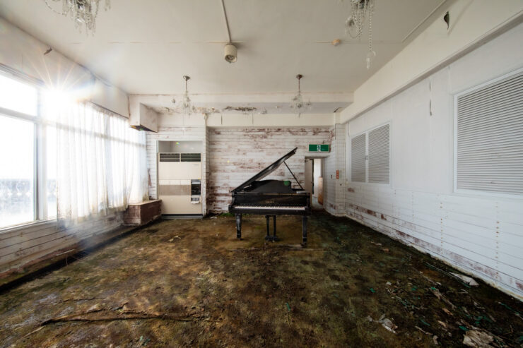 Decaying grandeur: Abandoned piano, derelict hotel interior