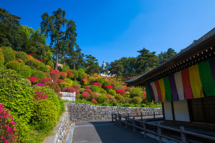 Tranquil Shiofunekannon-ji Temple in lush Japanese landscape with vibrant azalea bushes.