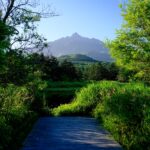 Rishiri Islands volcanic peak, lush meadows, winding stream.