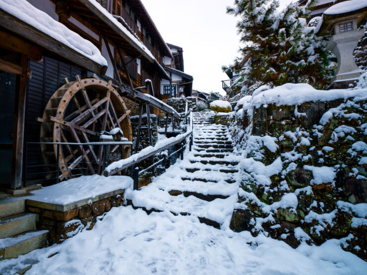 Snow-draped traditional Japanese village water wheel