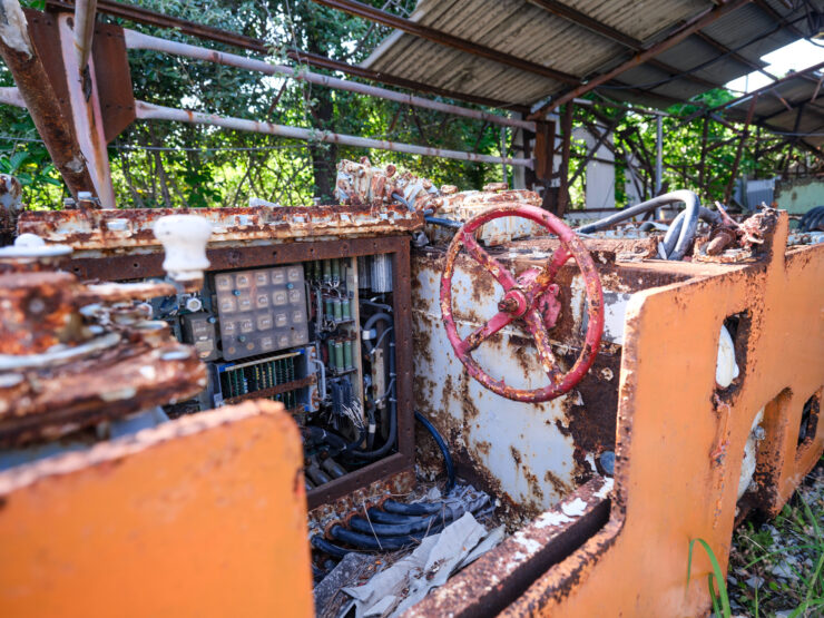 Decaying machinery engulfed by natures reclaim.