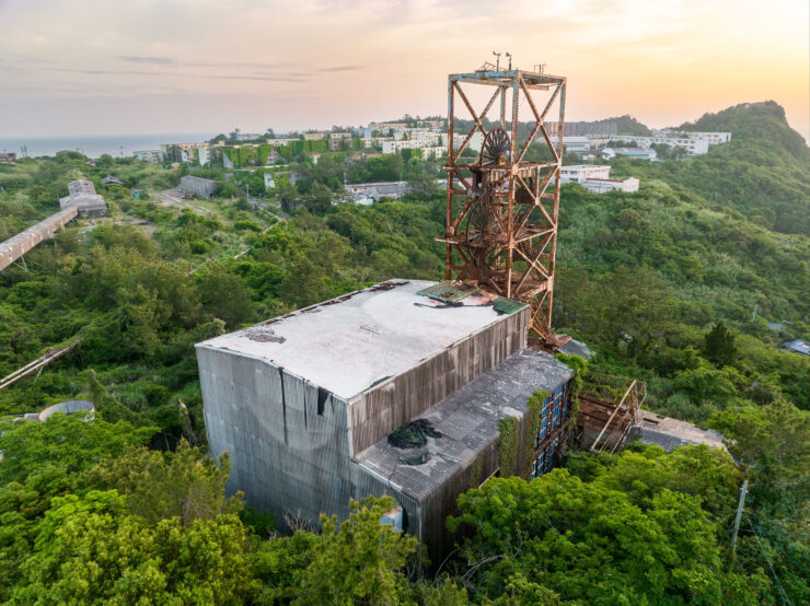 Overgrown industrial tower amidst lush nature scenery.