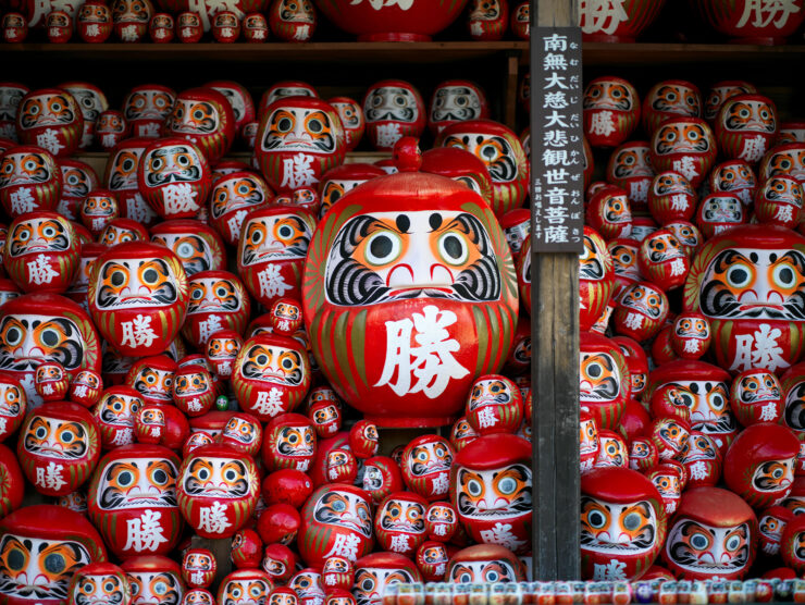 Iconic red Daruma dolls, symbols of perseverance.