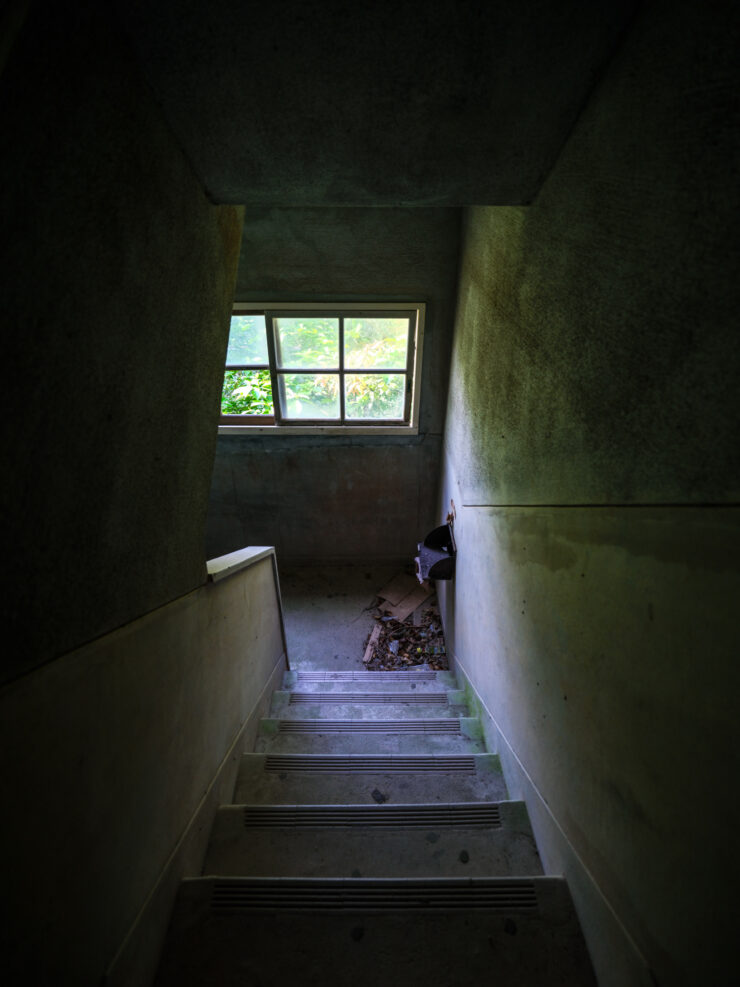 Eerie abandoned stairwell, derelict buildings haunting glimpse.
