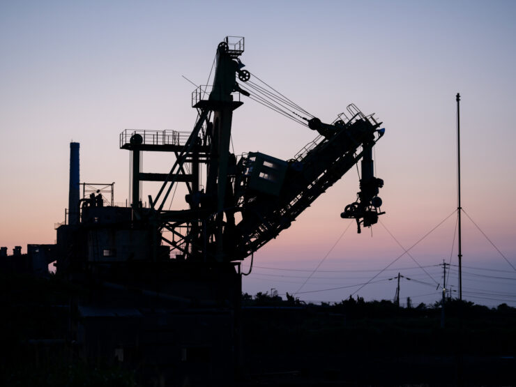 Industrial crane against fiery sunset sky