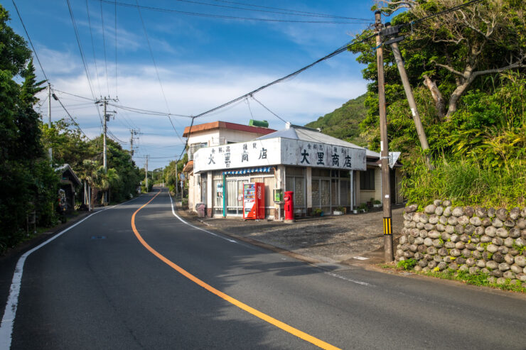 Tranquil Japanese village street, stone walls, red-roofed building.