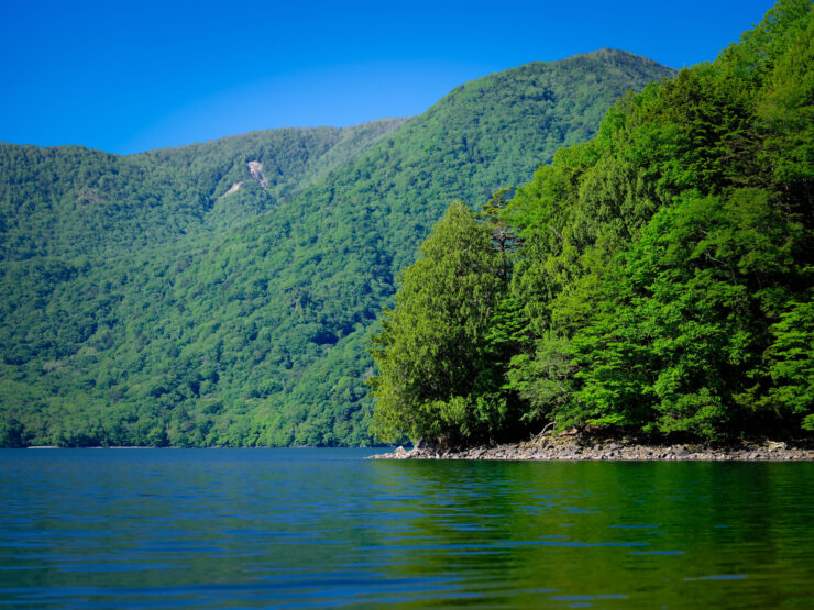Tranquil Green Lake Mirroring Towering Peaks