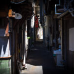 Onomichis historic dimly-lit alleyway, cluttered charm