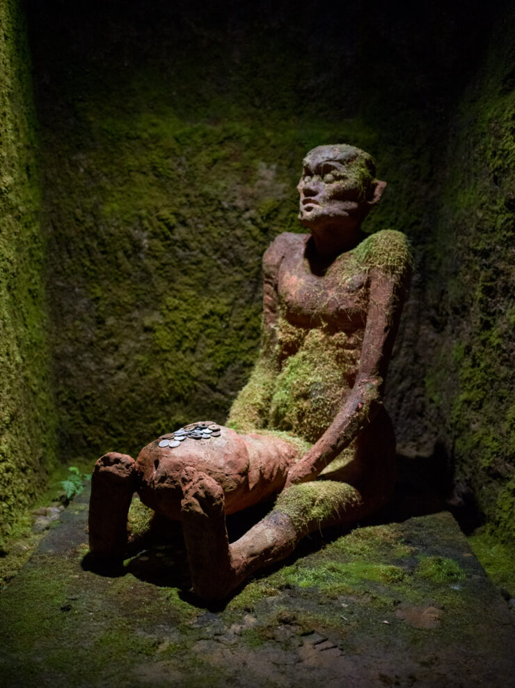 Moss-enveloped serene stone sculpture, natural haven