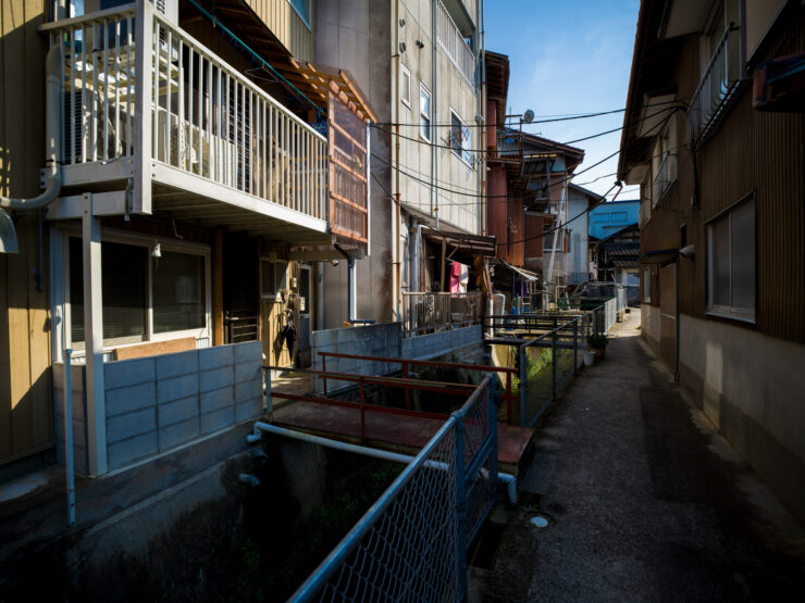 Atmospheric narrow Tokyo alley with aged brick buildings.