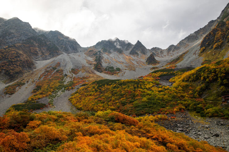 Vibrant autumn hues blanket rocky peaks in Karasawa