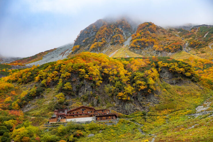 Autumn mountain chalets, colorful foliage, misty peaks.