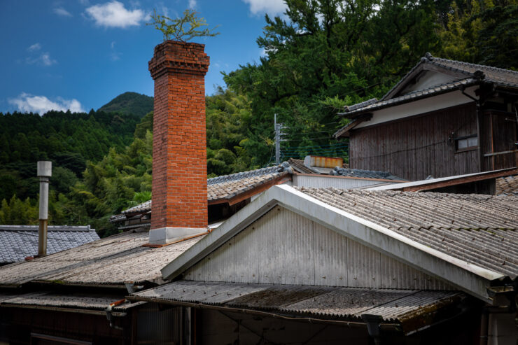 Tranquil Japanese village with thatched roofs, chimney.