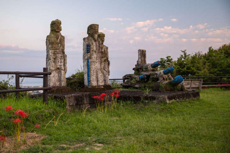 Ancient stone sculptures amid blooming flowers