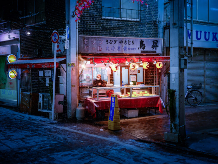 Cozy Japanese street food stall illuminated by lanterns