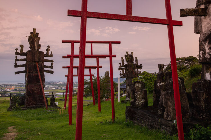 Vibrant torii gates trail through scenic Japanese shrine landscape.