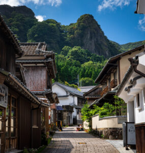 Picturesque Japanese village street, wooden buildings, mountains