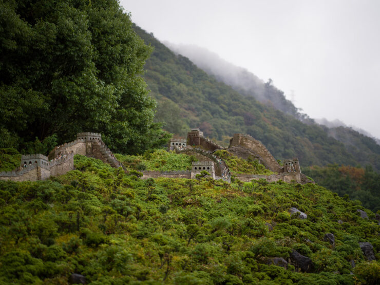 Miniature ancient castle ruins, lush landscape.