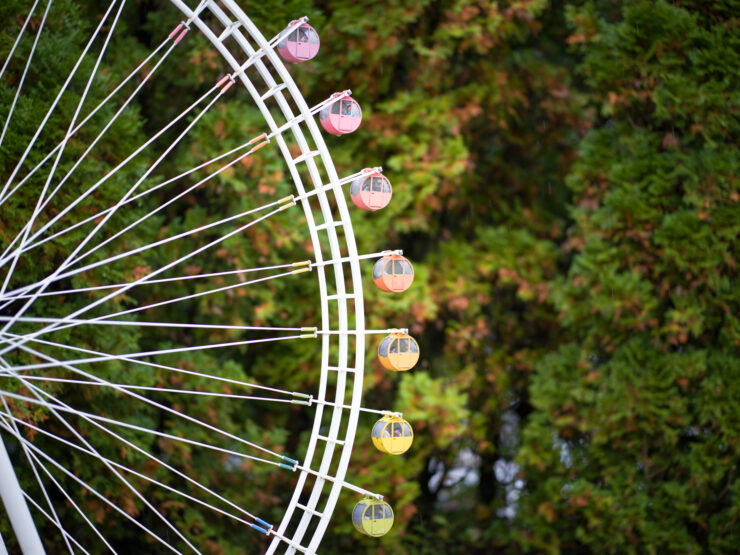 Colorful ferris wheel in lush park setting.