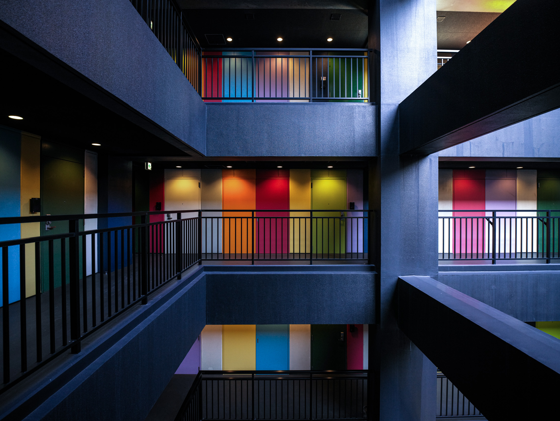 Soho Odaiba Tokyo atrium with multi-level concrete walkways and rainbow wall panels