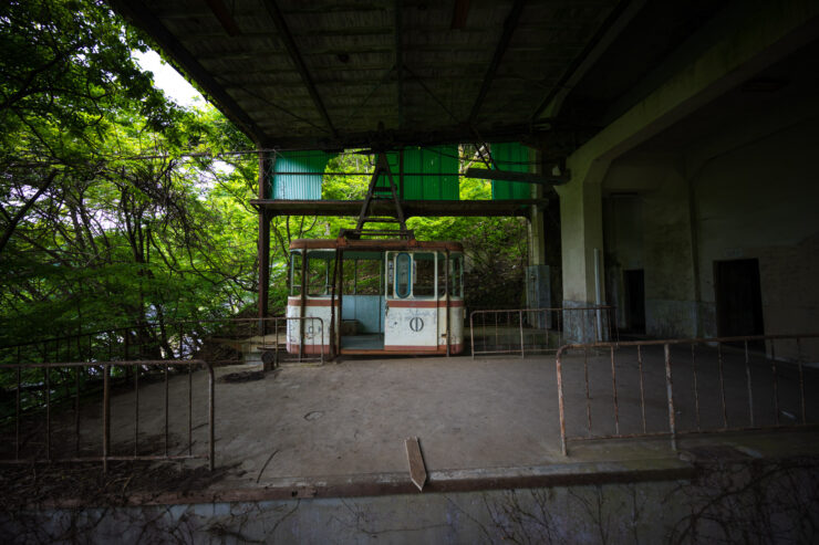 Dilapidated ropeway station overtaken by flourishing forest.