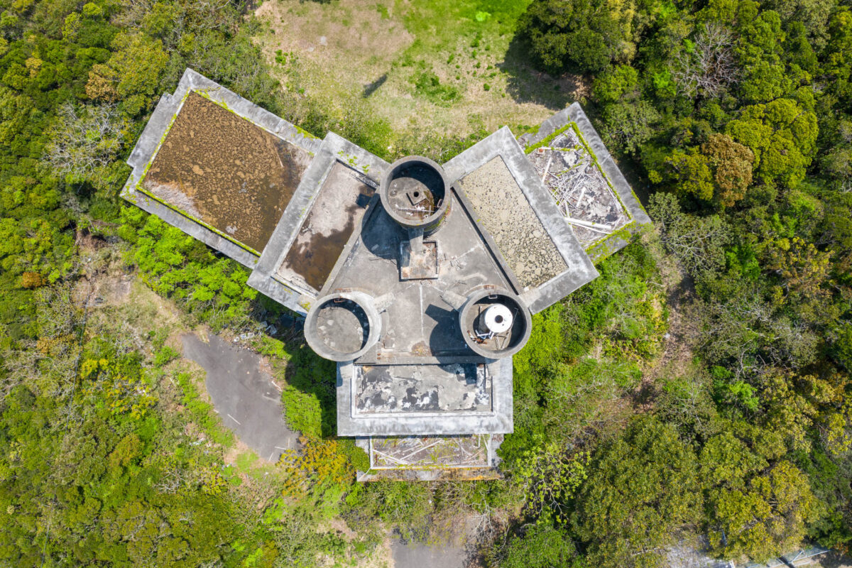 Top-down aerial of abandoned New Muroto Sky Resort amid dense forest greenery