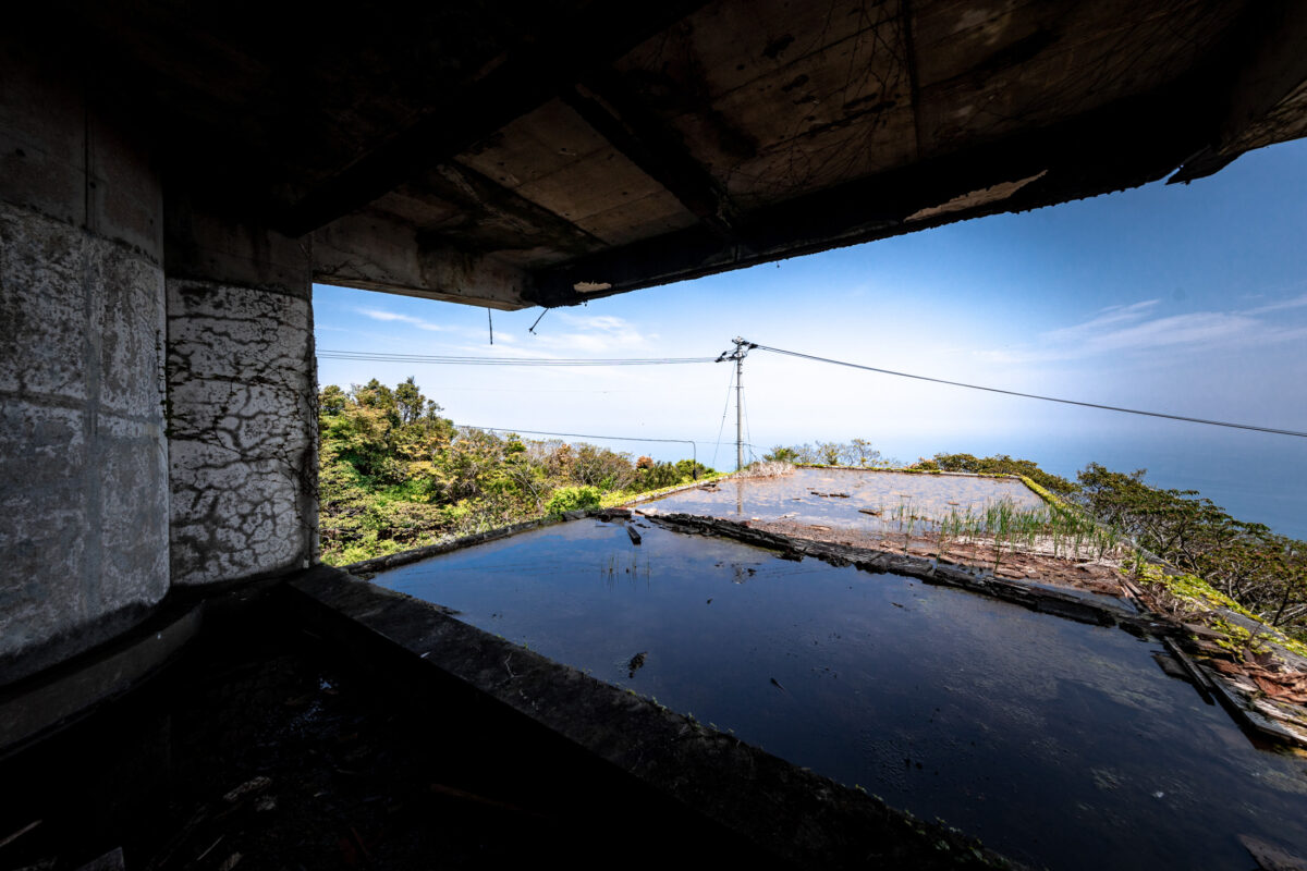 Abandoned New Muroto Sky Resort framing coastal ocean view with reflecting pool