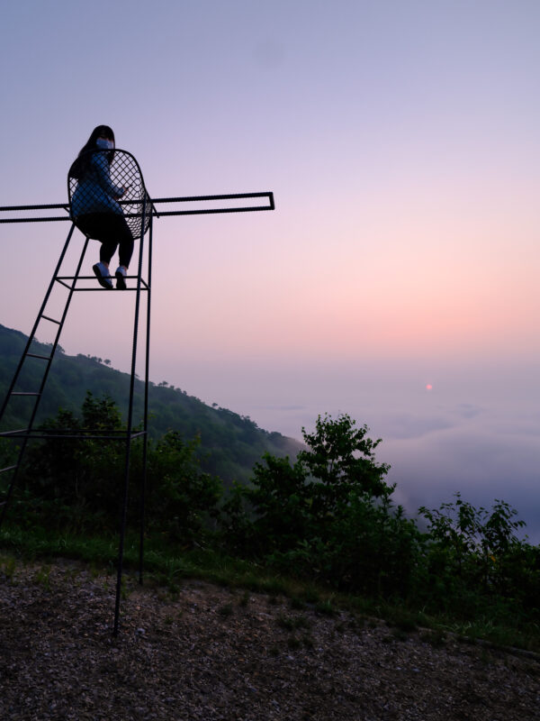 Traveler on Unkai Terrace overlooking a sea of clouds at pastel mountain sunrise